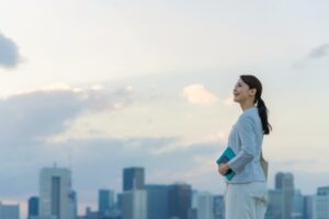 Woman stands over town skyline with hope.