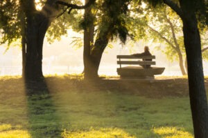 A man grieving on a park bench. Find out how to handle your family’s legal needs with an Atlanta wrongful death lawyer.