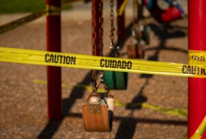 Caution tape protects swings at a Georgia playground. A premises liability attorney can help after an outdoor accident.